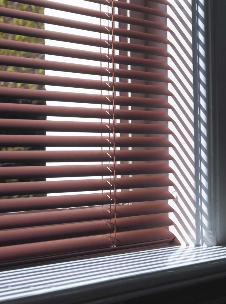 Image gros plan d'un store en aluminium brun sur une fenêtre