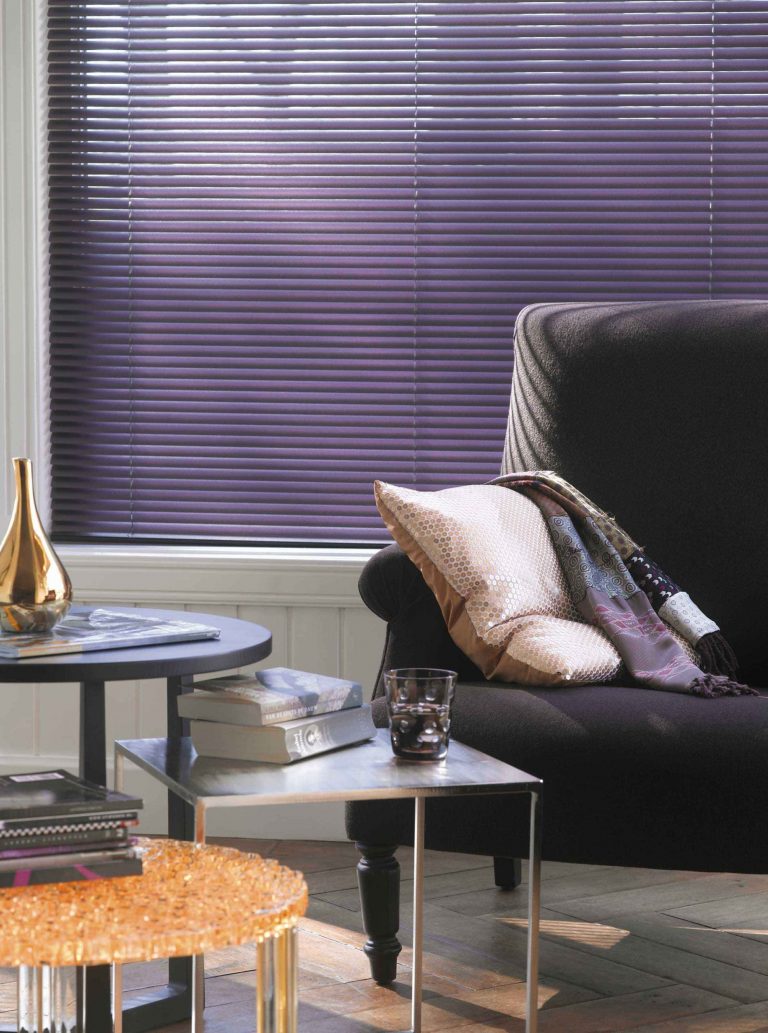 Salon moderne avec un canapé noir, table en bois, et un store violet en aluminium